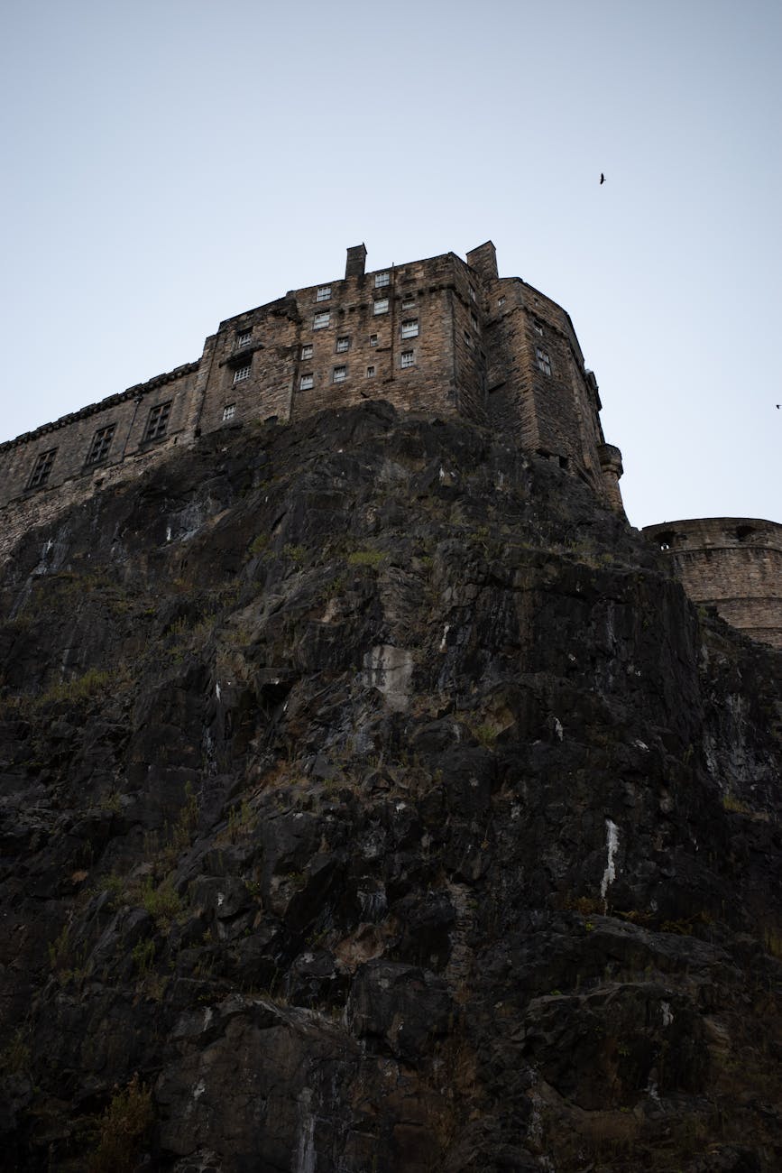 Edinburgh Castle perched on volcanic rock against dramatic sky