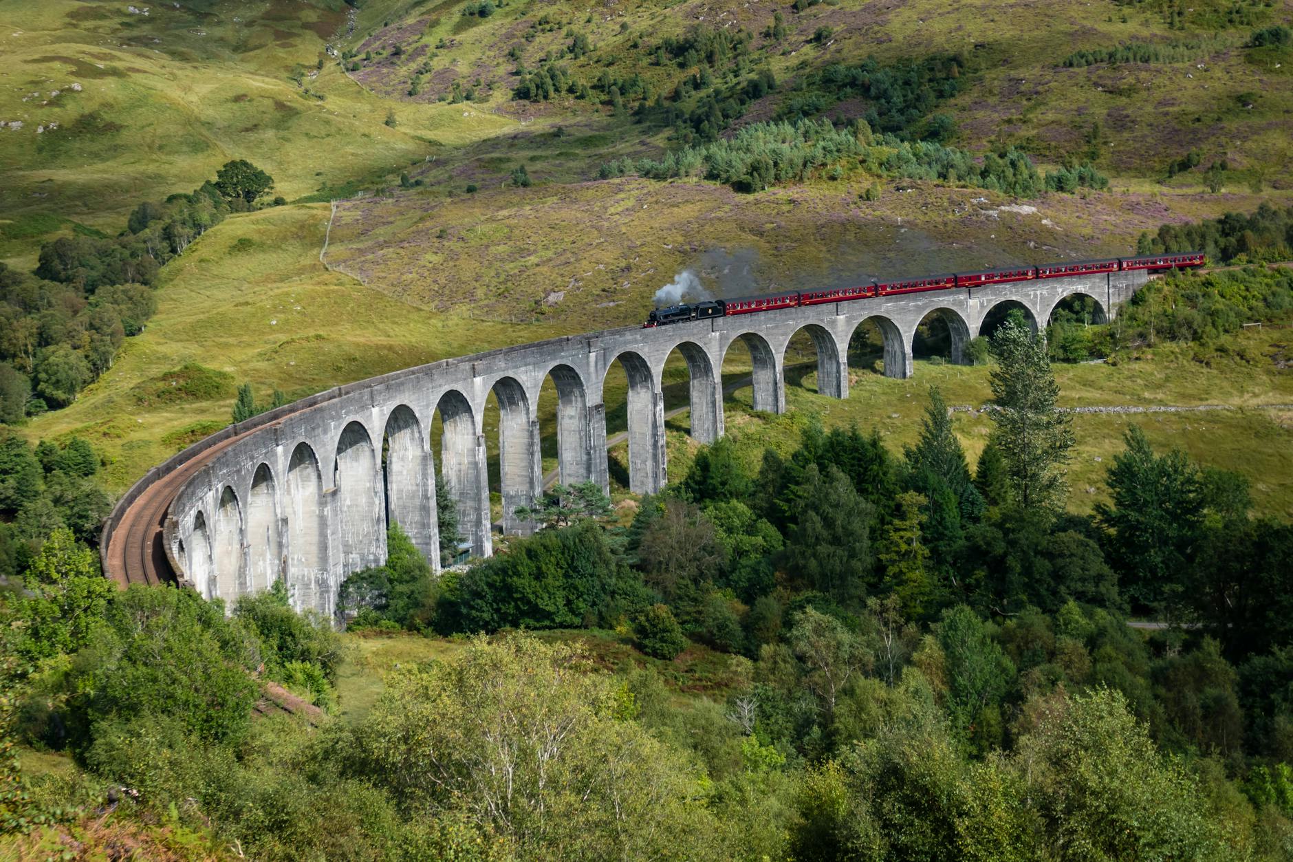 Steam train crossing Glenfinnan Viaduct in the Scottish Highlands