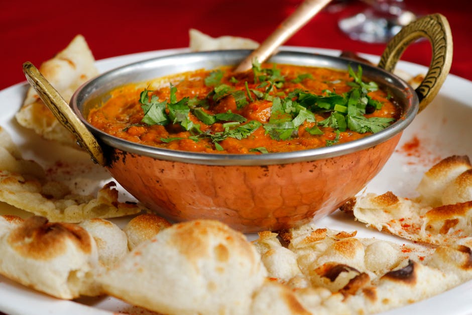 Aromatic Indian curry dishes served in traditional bowls with naan bread at a Glasgow curry house