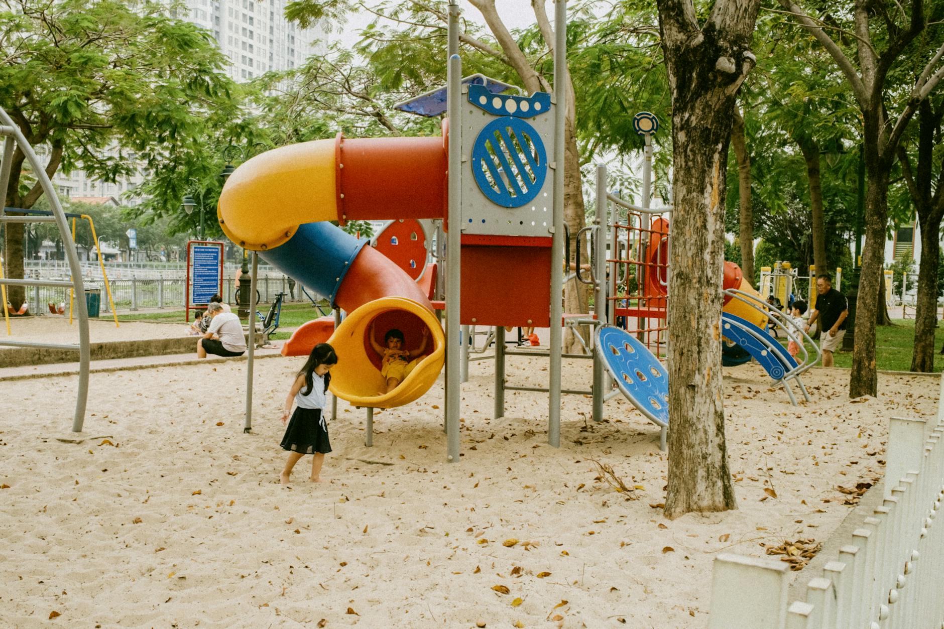 Children playing on colourful playground equipment in a Glasgow park