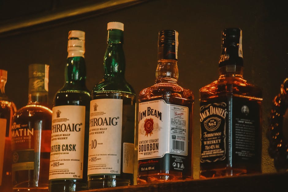 Premium whisky bottles elegantly arranged on illuminated bar shelves in Glasgow