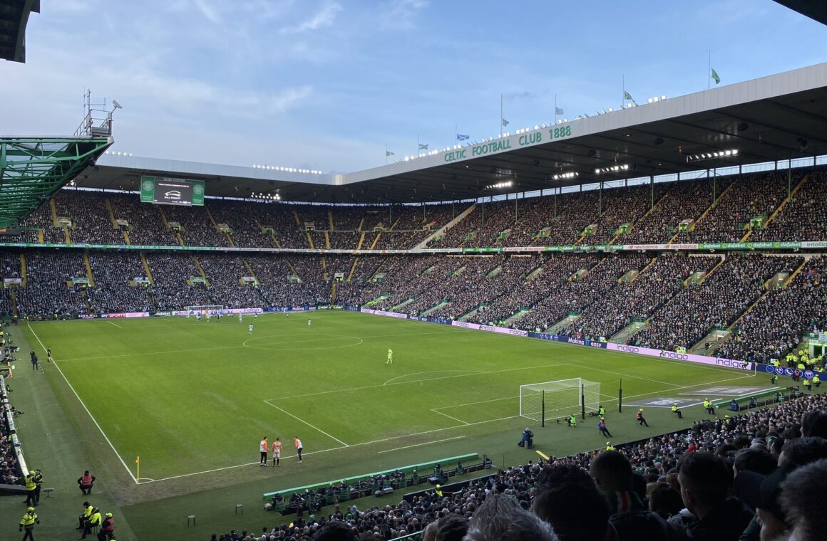 A packed Celtic Park seen from the upper tier during a match, with all four stands full