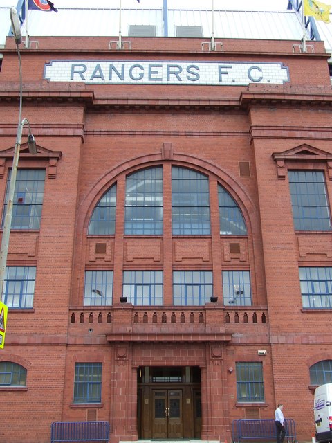 The red-brick main entrance of the Ibrox Main Stand with RANGERS F.C. lettering above an arched window and wooden double doors