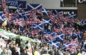 Union flags and saltires on one side of a stand meeting Irish tricolours and green banners on the other during an Old Firm derby