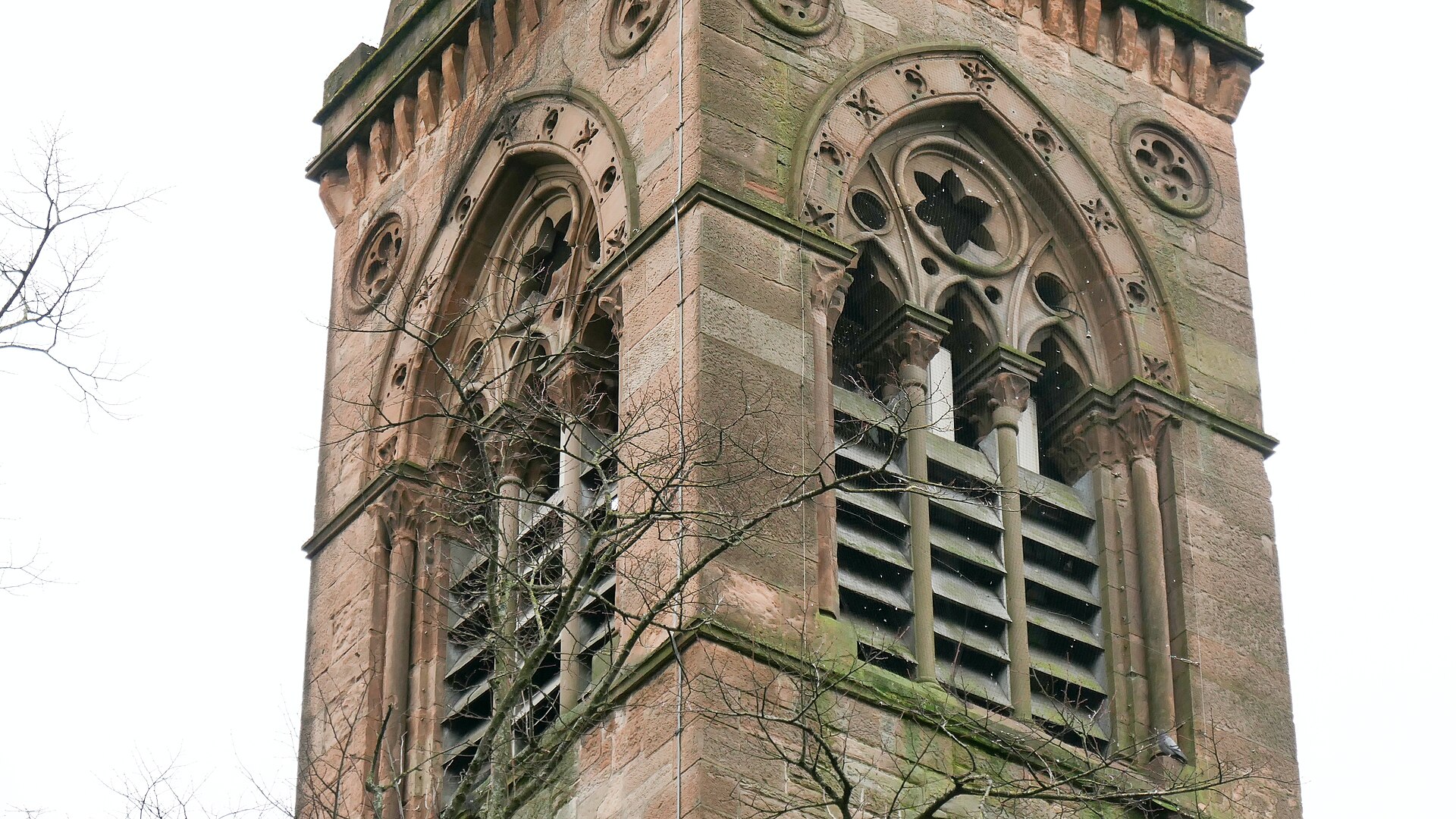 The Gothic sandstone bell tower of the former Kelvinside Botanic Gardens Church, now Òran Mór, with carved arches and louvred openings