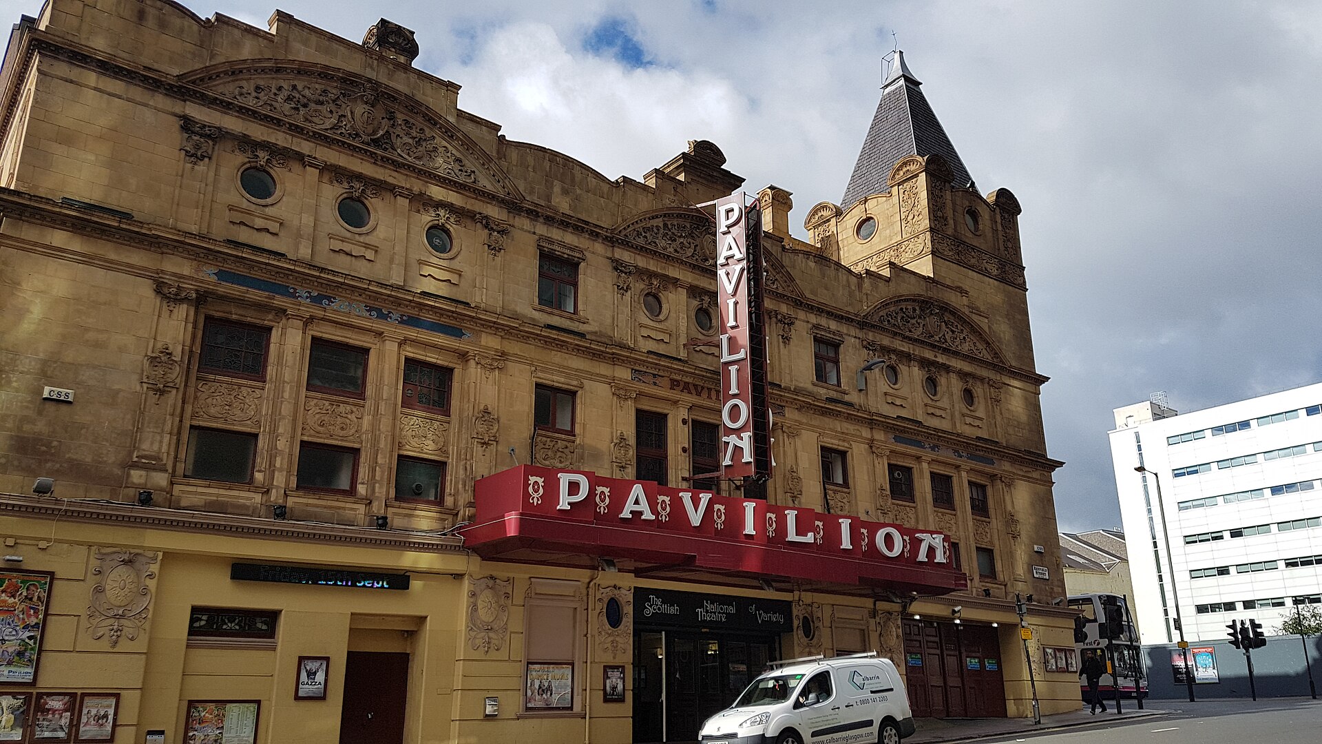 The ornate yellow sandstone frontage of the Pavilion Theatre on Renfield Street, with its red PAVILION canopy and vertical sign